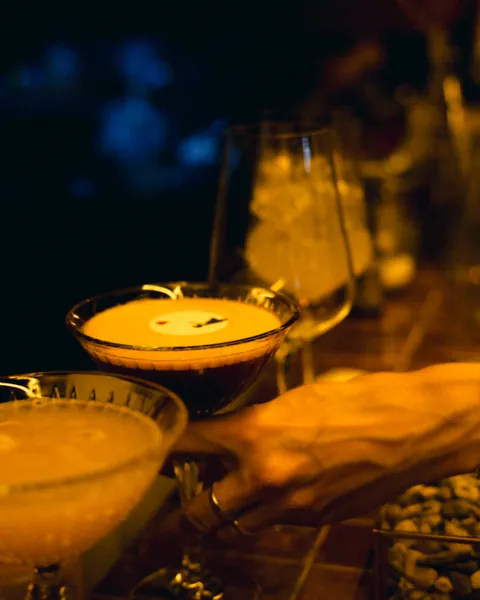 A set of author cocktails served on wood by candlelight at Čin Čin